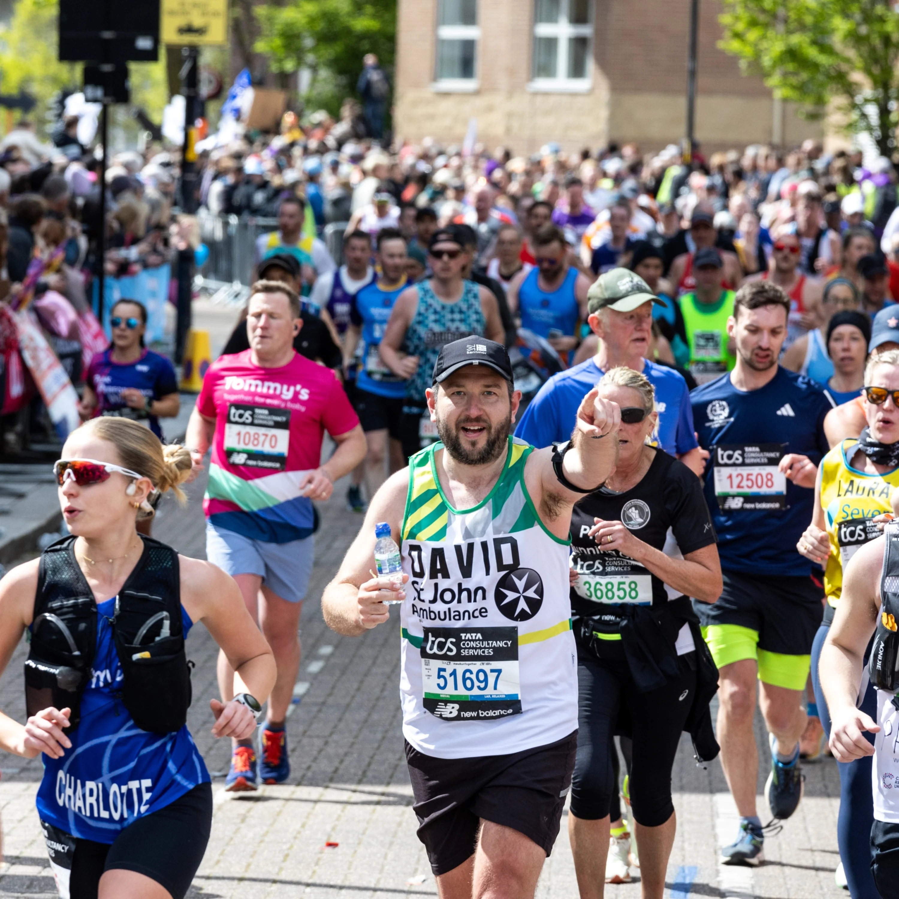 Marathon runners, with one St John Ambulance fundraiser pointing at the photographer.