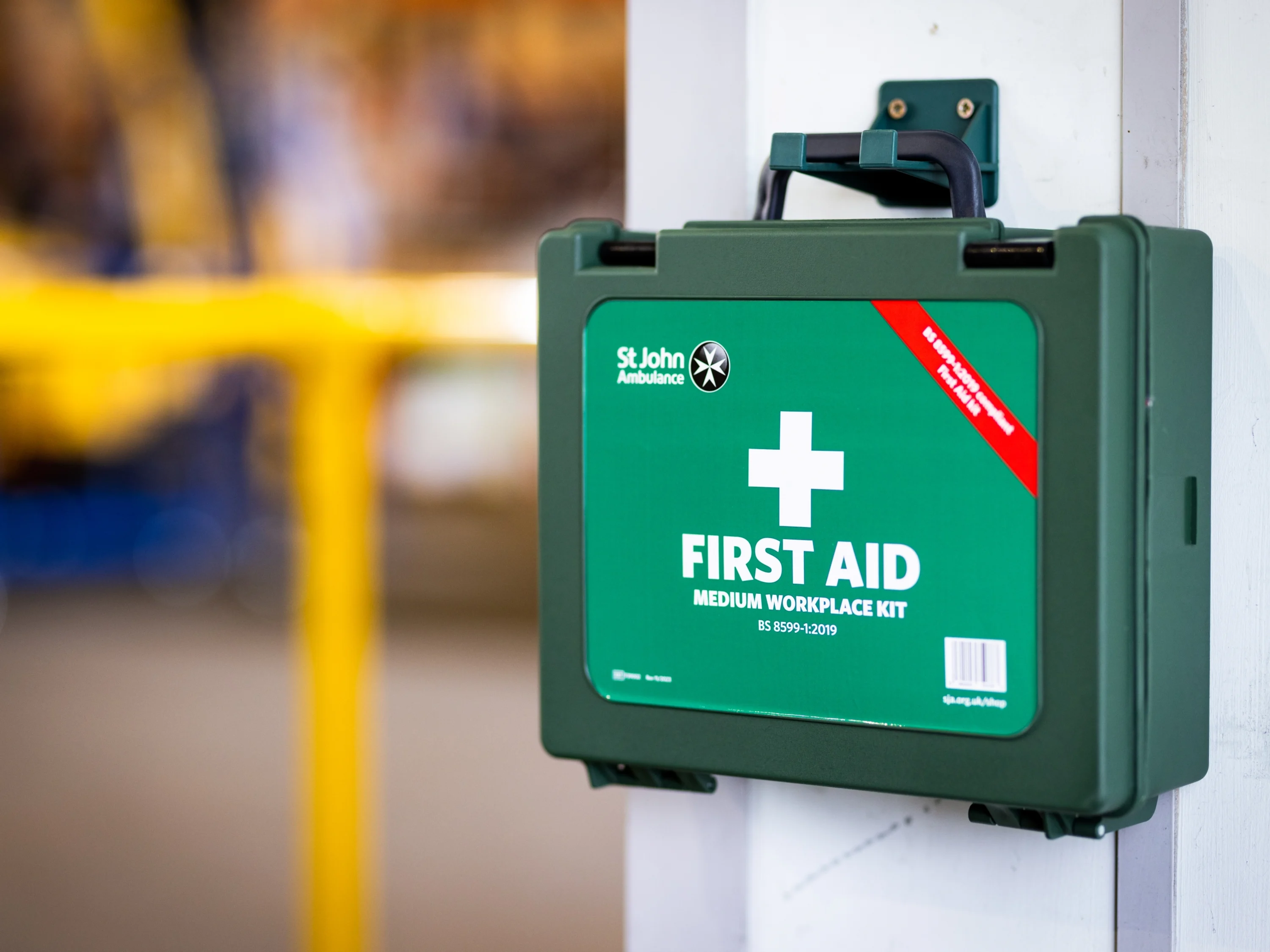 A photograph of a first aid kit placed in an easy to find locations in a workplace.