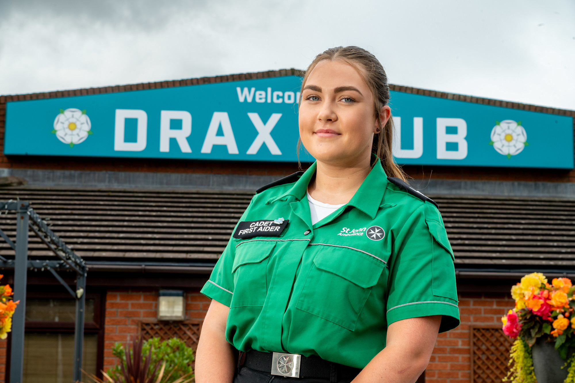 Millie Lockwood wearing her Cadet First Aider uniform standing in front of the Drax Club.