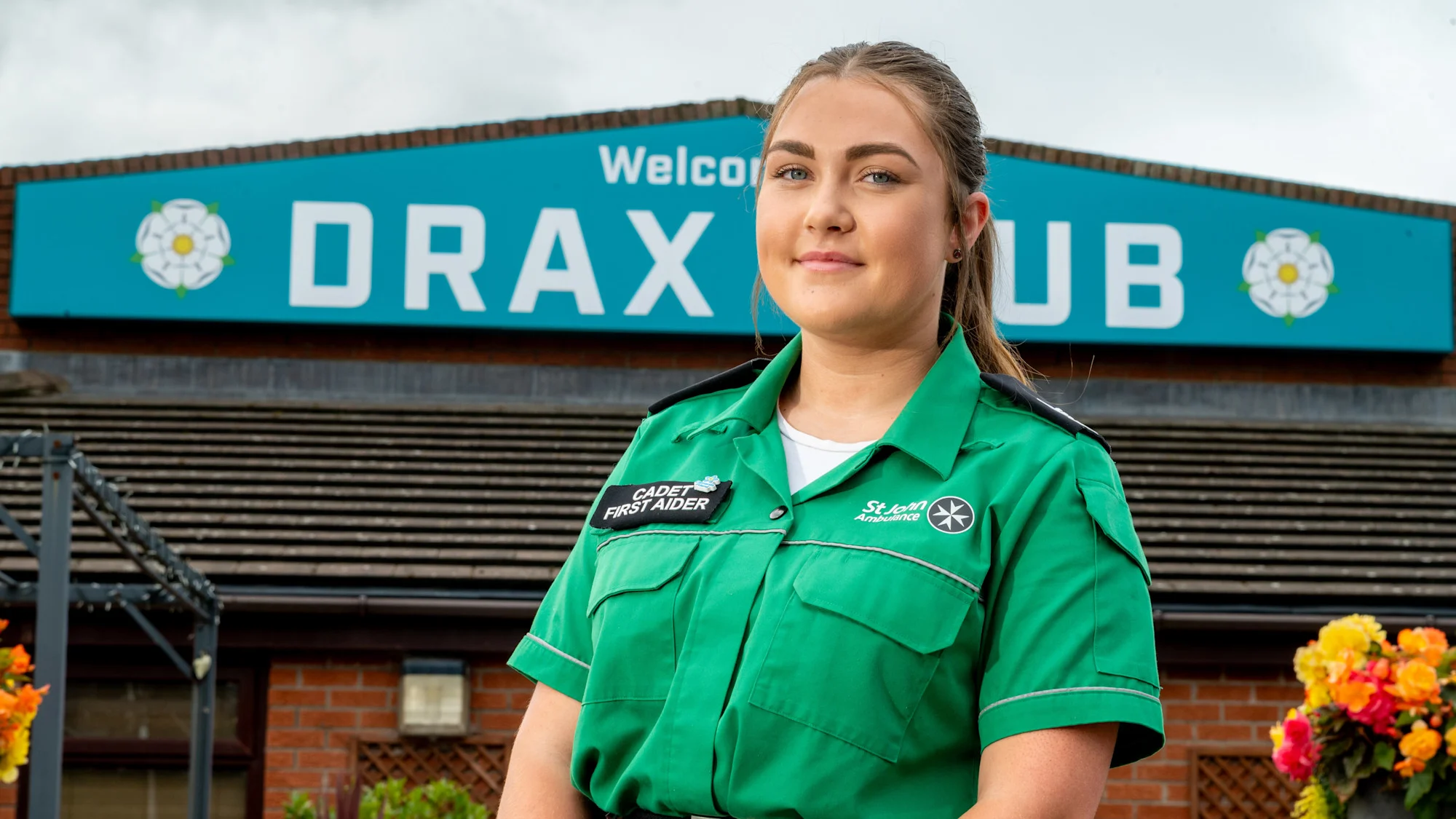 Millie Lockwood wearing her Cadet First Aider uniform standing in front of the Drax Club.
