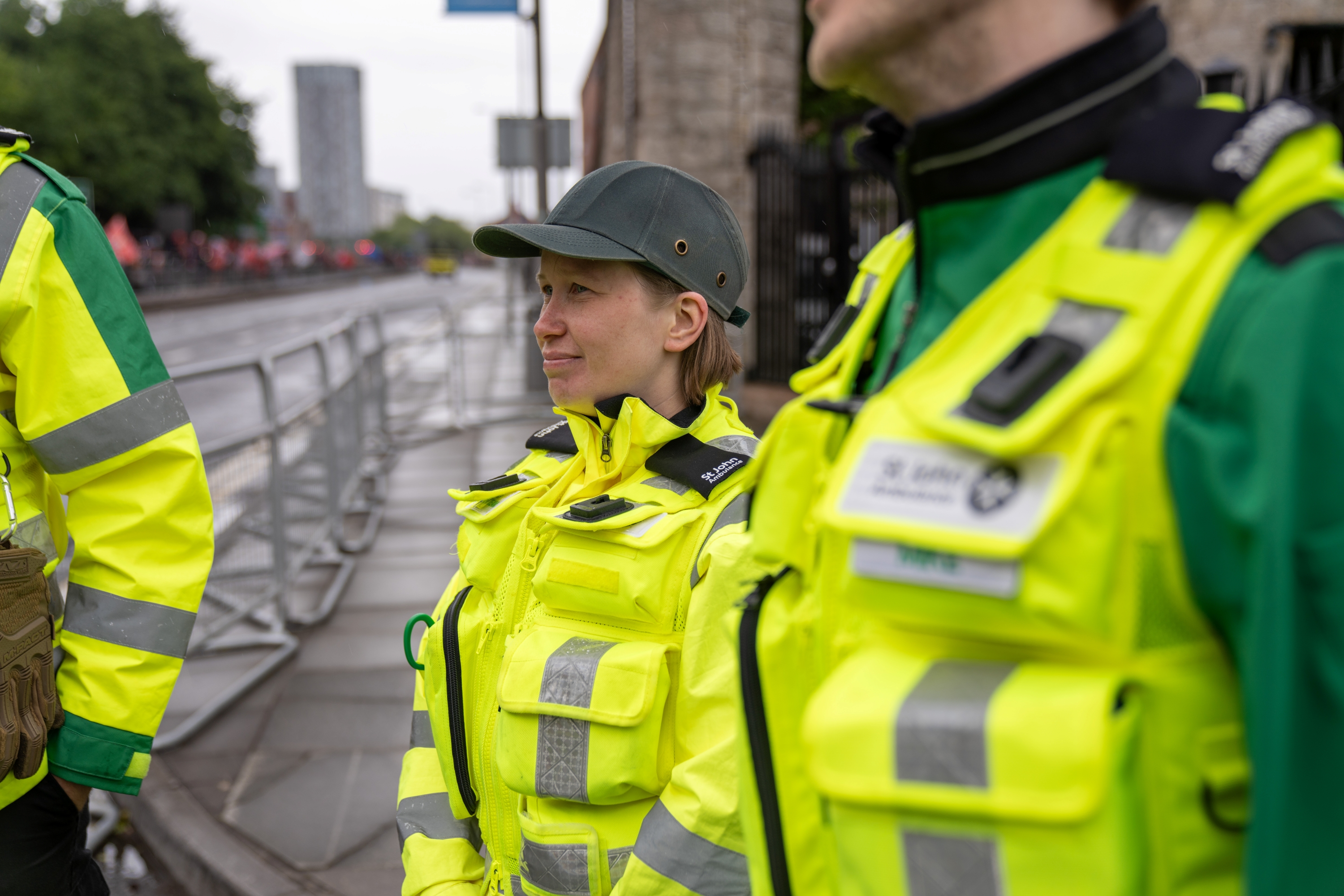Three volunteers wearing high-vis Medical Response Team jackets stood outside on an empty city road. 