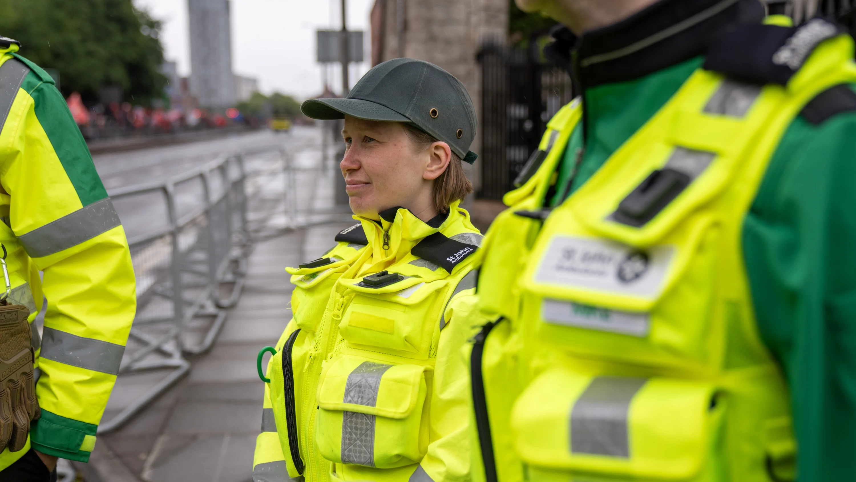 Three volunteers wearing high-vis Medical Response Team jackets stood outside on an empty city road.