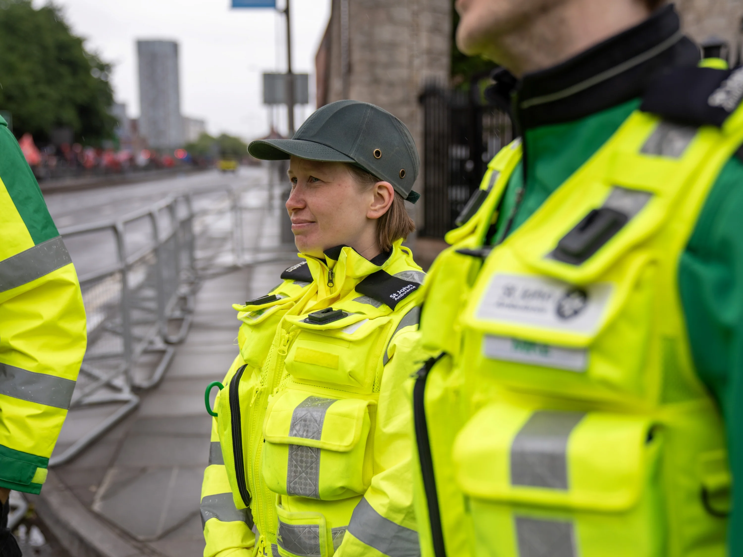 Three volunteers wearing high-vis Medical Response Team jackets stood outside on an empty city road.