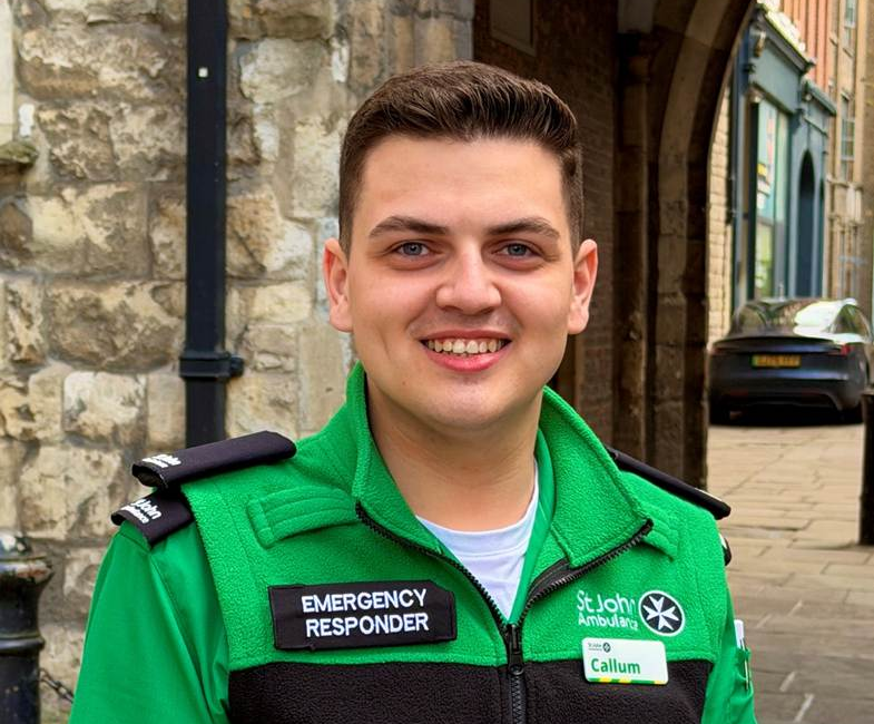 St John Ambulance Emergency Responder Callum smiling while stood in front of St John's Gate near the organisation's national headquarters.