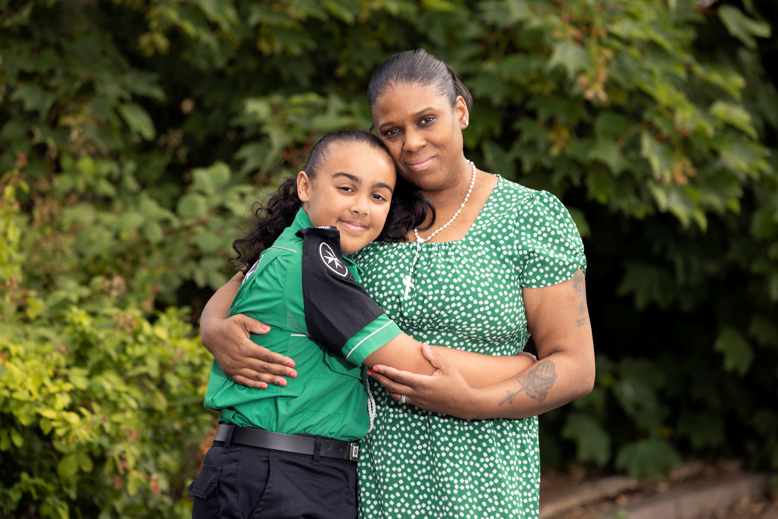 A photograph of Jayden in her St John uniform hugging her mum, Tash.