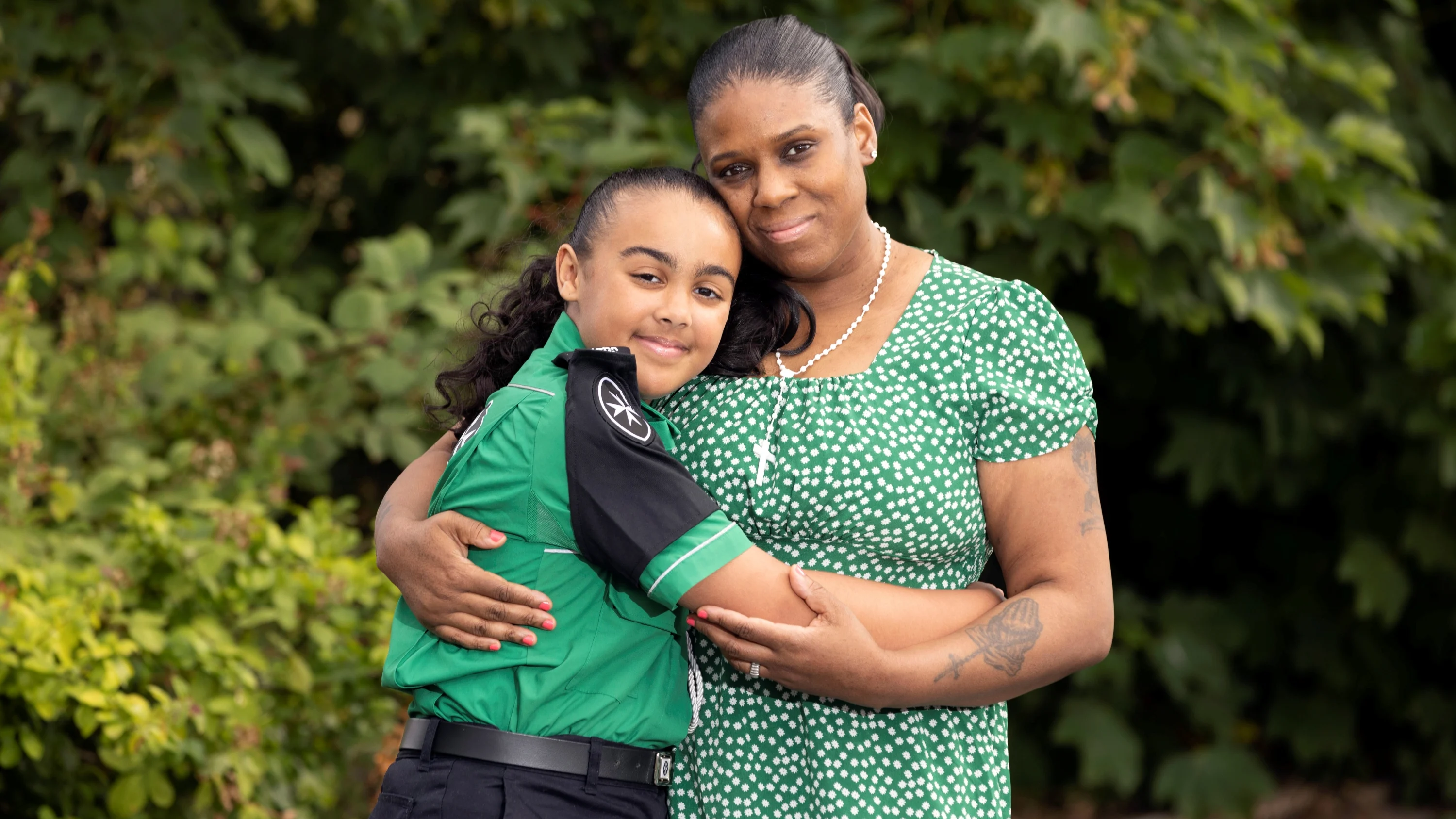 A photograph of Jayden in her St John uniform hugging her mum, Tash.