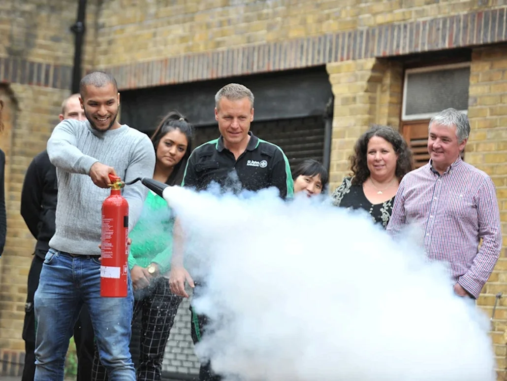 A photograph of people testing fire extinguishers on a fire marshals course
