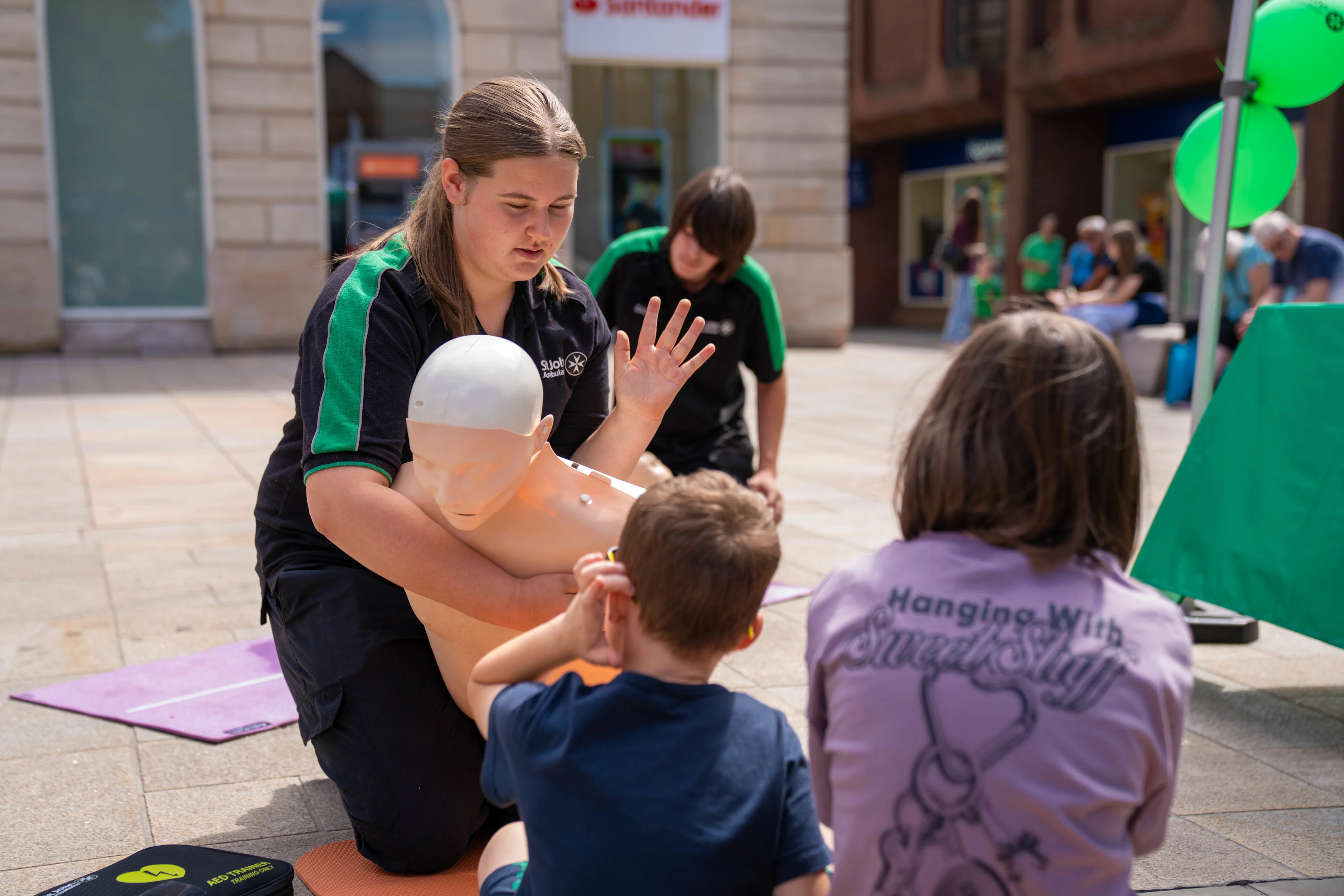 A St John Ambulance trainer giving children a demonstration on how to prevent choking.
