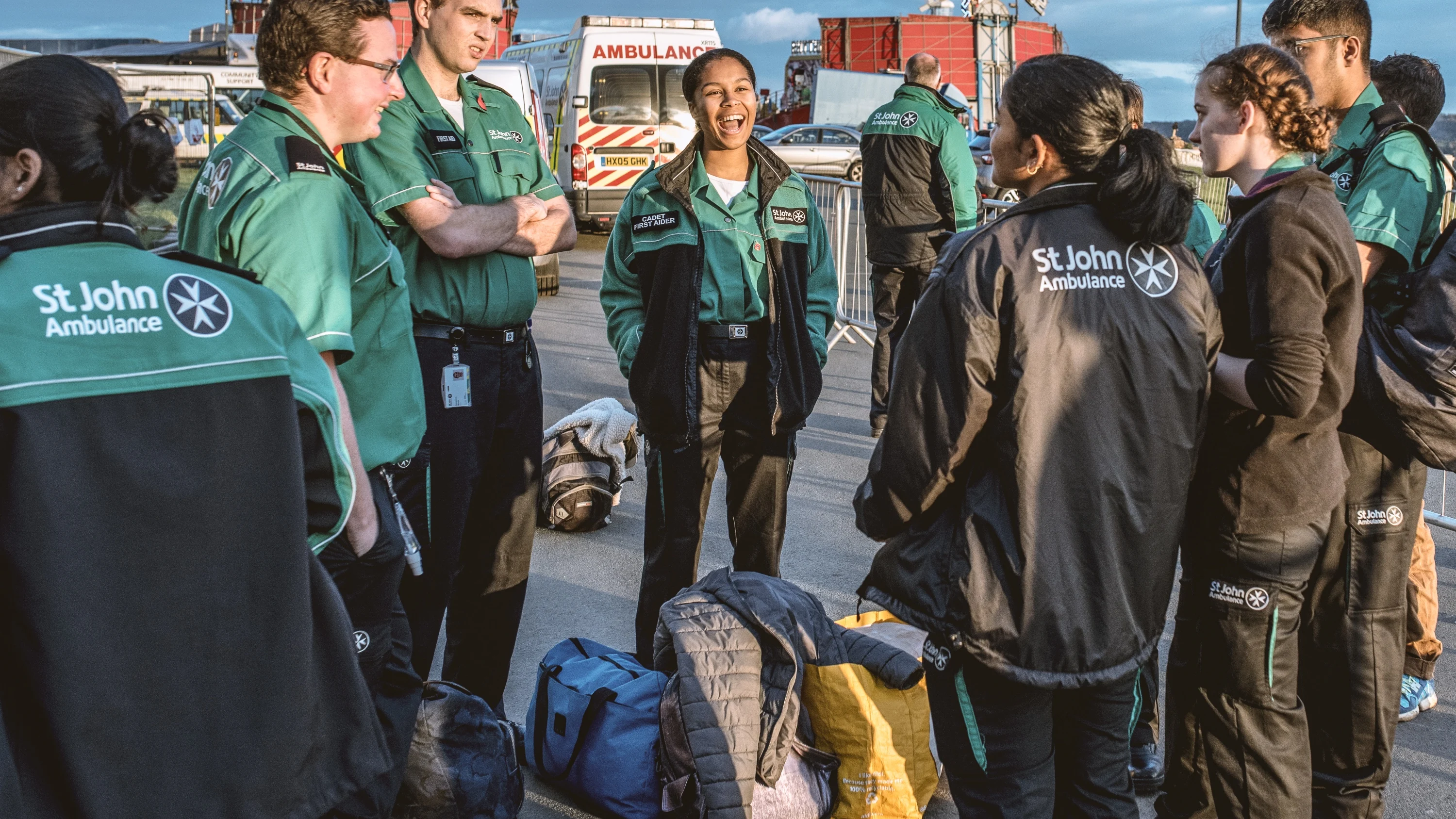 A photograph of Mary standing outside and laughing with a group of other St John Ambulance Cadets and volunteers.