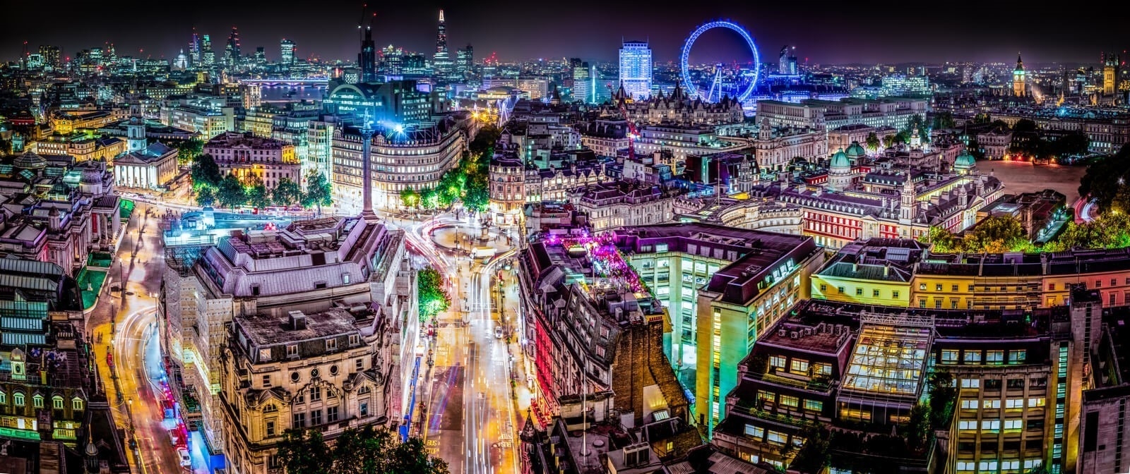 An aerial photograph of London at night, lit up by buildings, streetlights, and traffic.