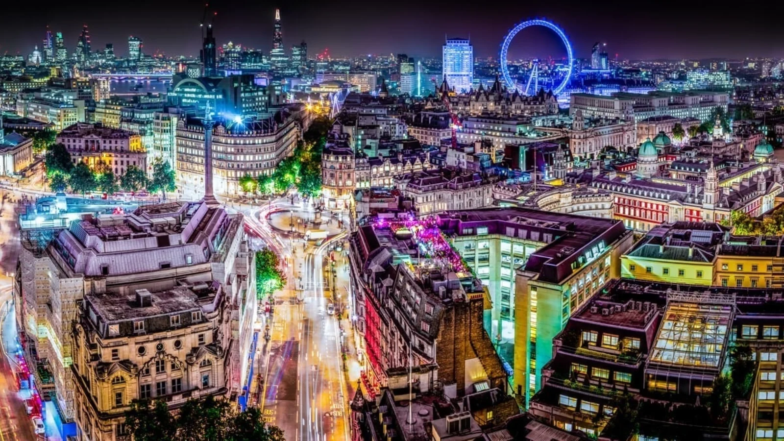 An aerial photograph of London at night, lit up by buildings, streetlights, and traffic.