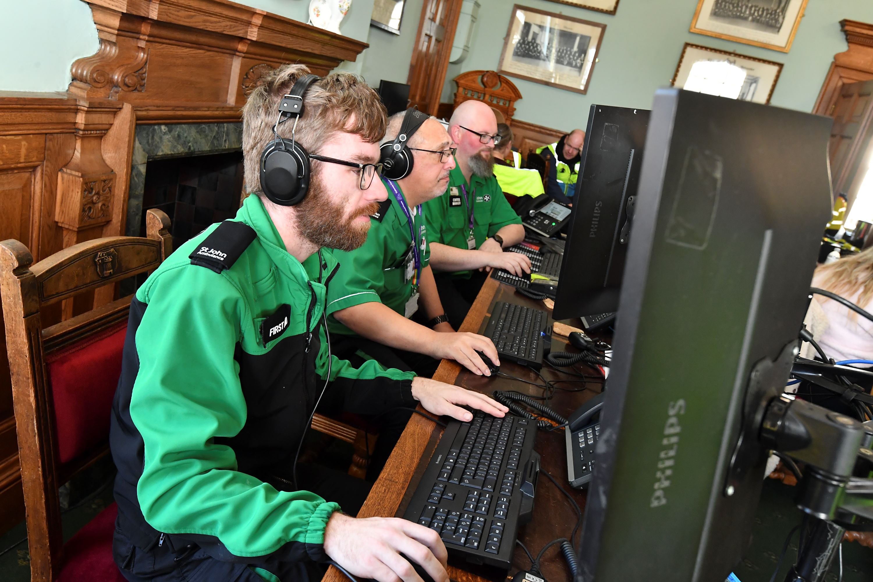 Operational Support team members at a bank of computers and telephones, supporting volunteers.
