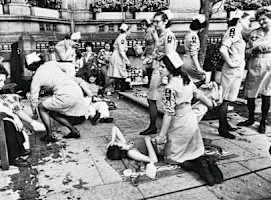 A black and white photograph of female SJA volunteers attending to large numbers of casualties.