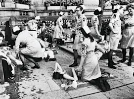 A black and white photograph of female SJA volunteers attending to large numbers of casualties.