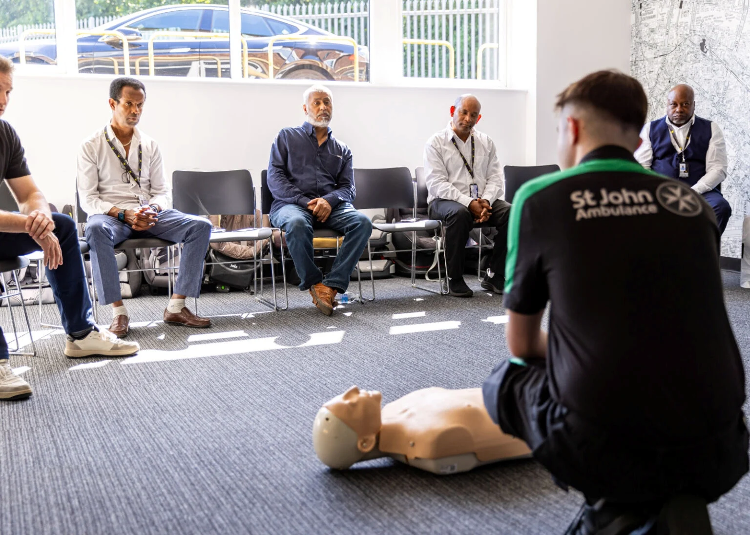 A St John Ambulance trainer delivering CPR and defibrillator sessions to Addison Lee drivers.
