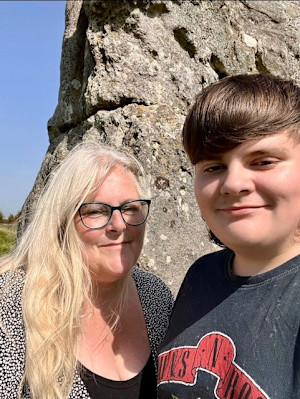 A selfie of Dylan and his mum. A large rock and blue sky can be seen in the background.
