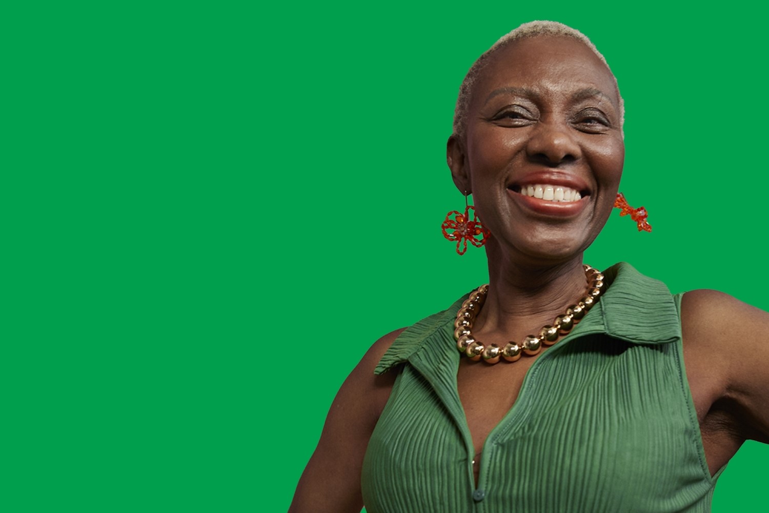 A portrait photo of a person smiling with a bright green background.