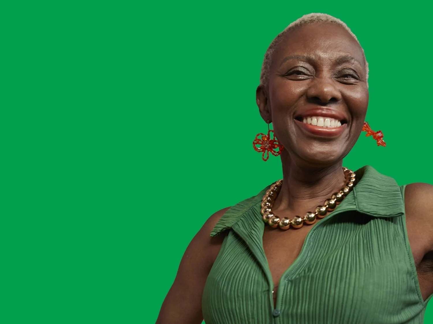 A portrait photo of a person smiling with a bright green background.