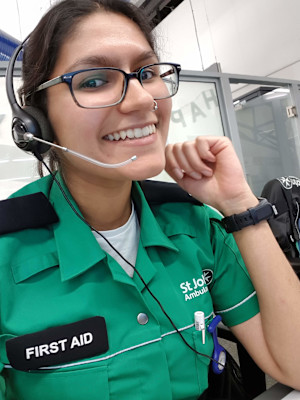 A photograph of Mausum in her St John uniform, smiling and wearing a headset.