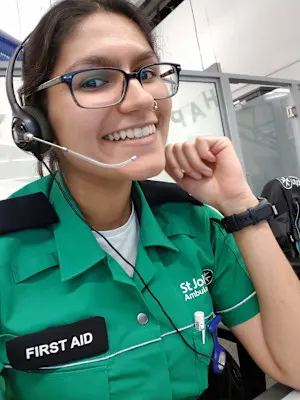 A photograph of Mausum in her St John uniform, smiling and wearing a headset.