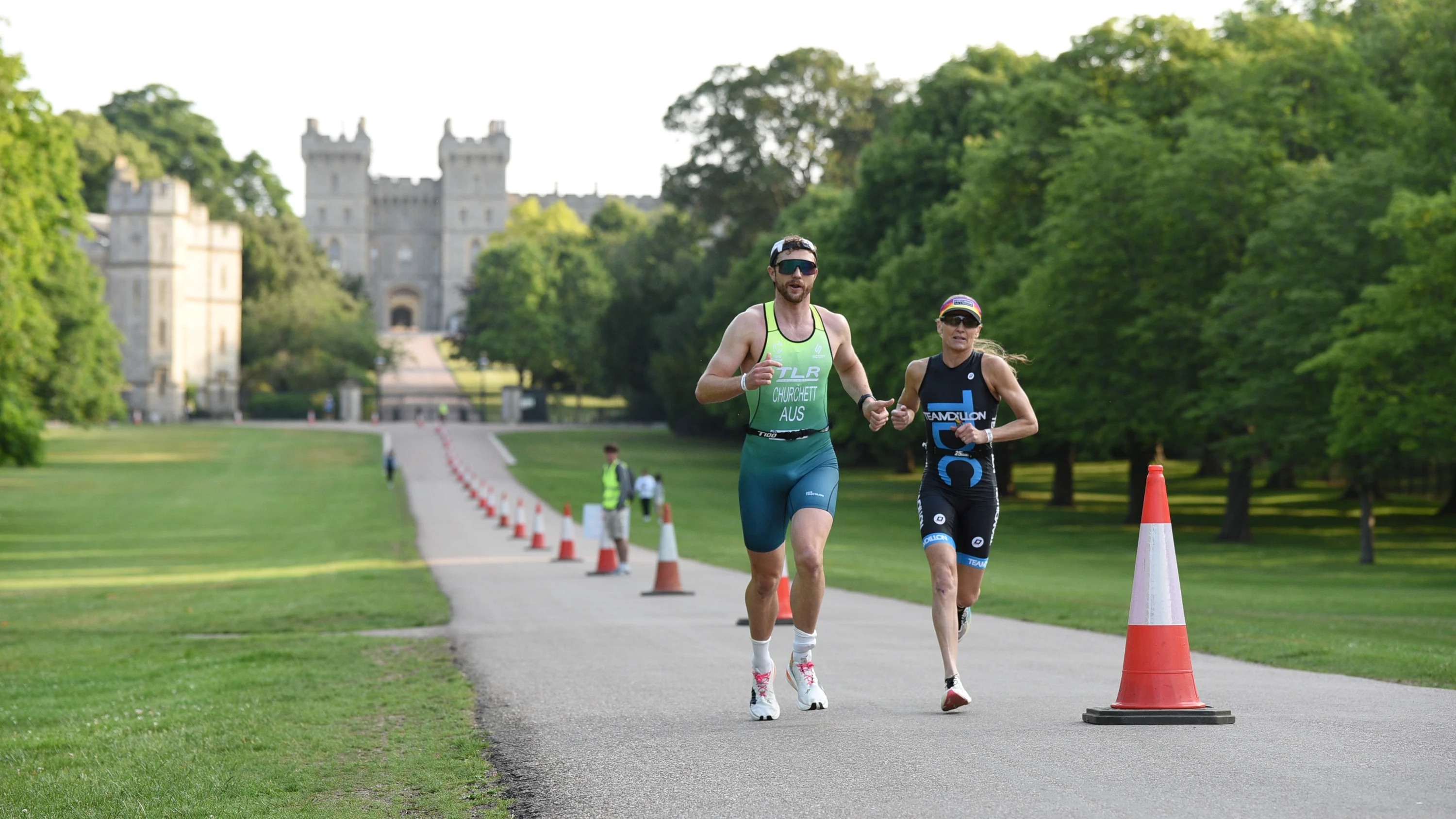 Two runners running along the road outside Windsor Castle as part of the Royal Windsor Triathlon.