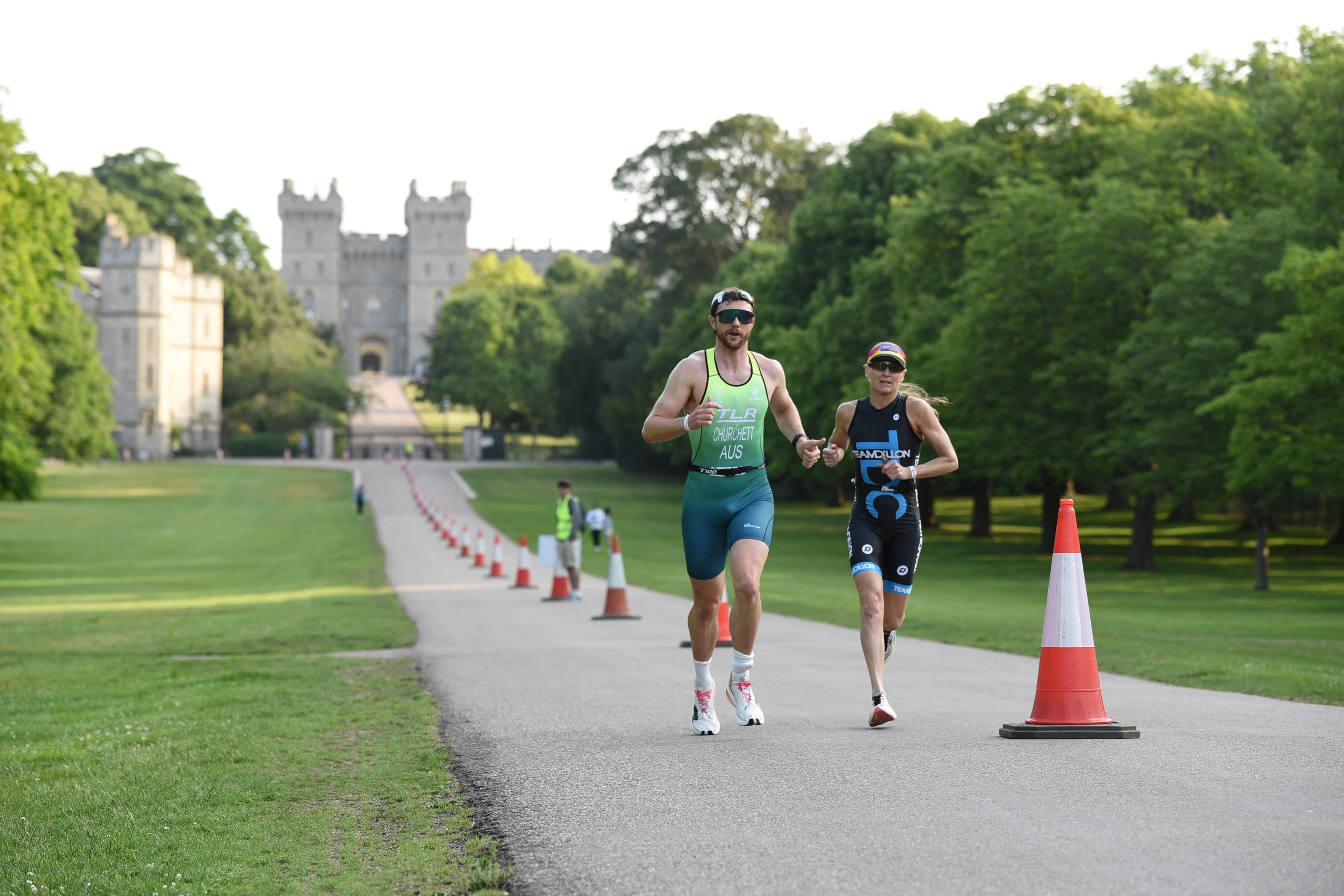 Two runners running along the road outside Windsor Castle as part of the Royal Windsor Triathlon.