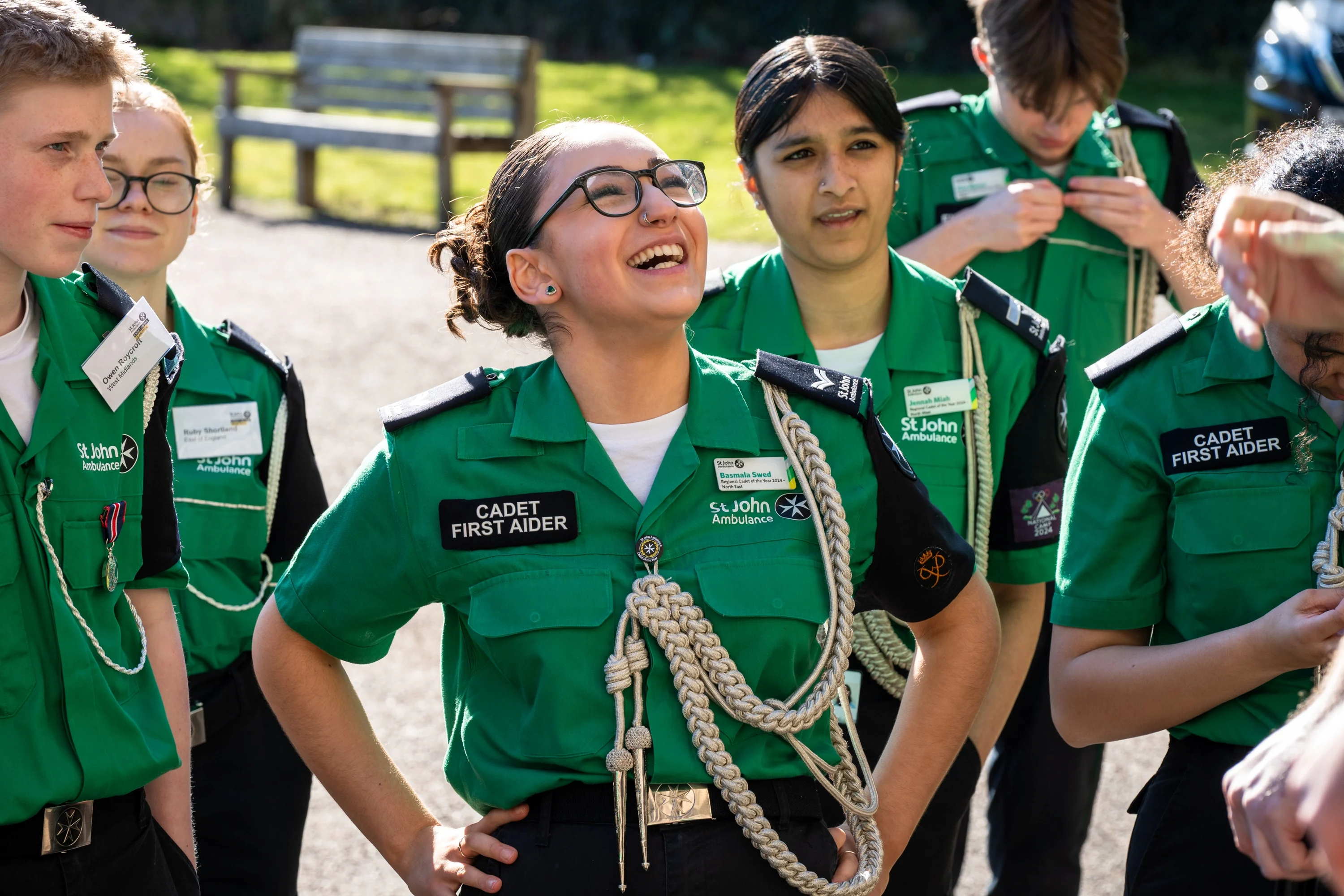 A group of Cadet First Aiders, one has their hands on their waist with a big smile on their face. 