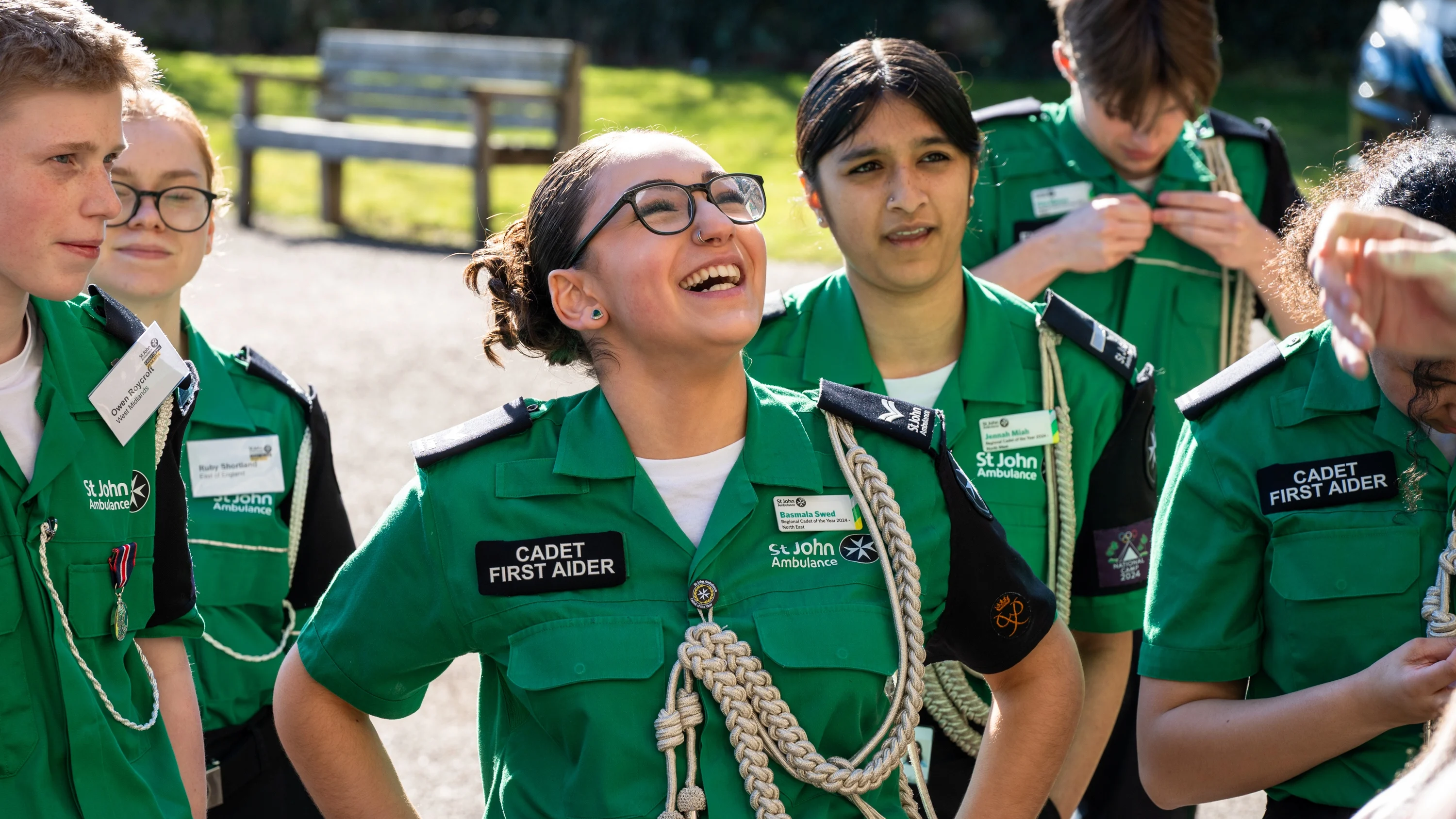 A group of Cadet First Aiders, one has their hands on their waist with a big smile on their face.