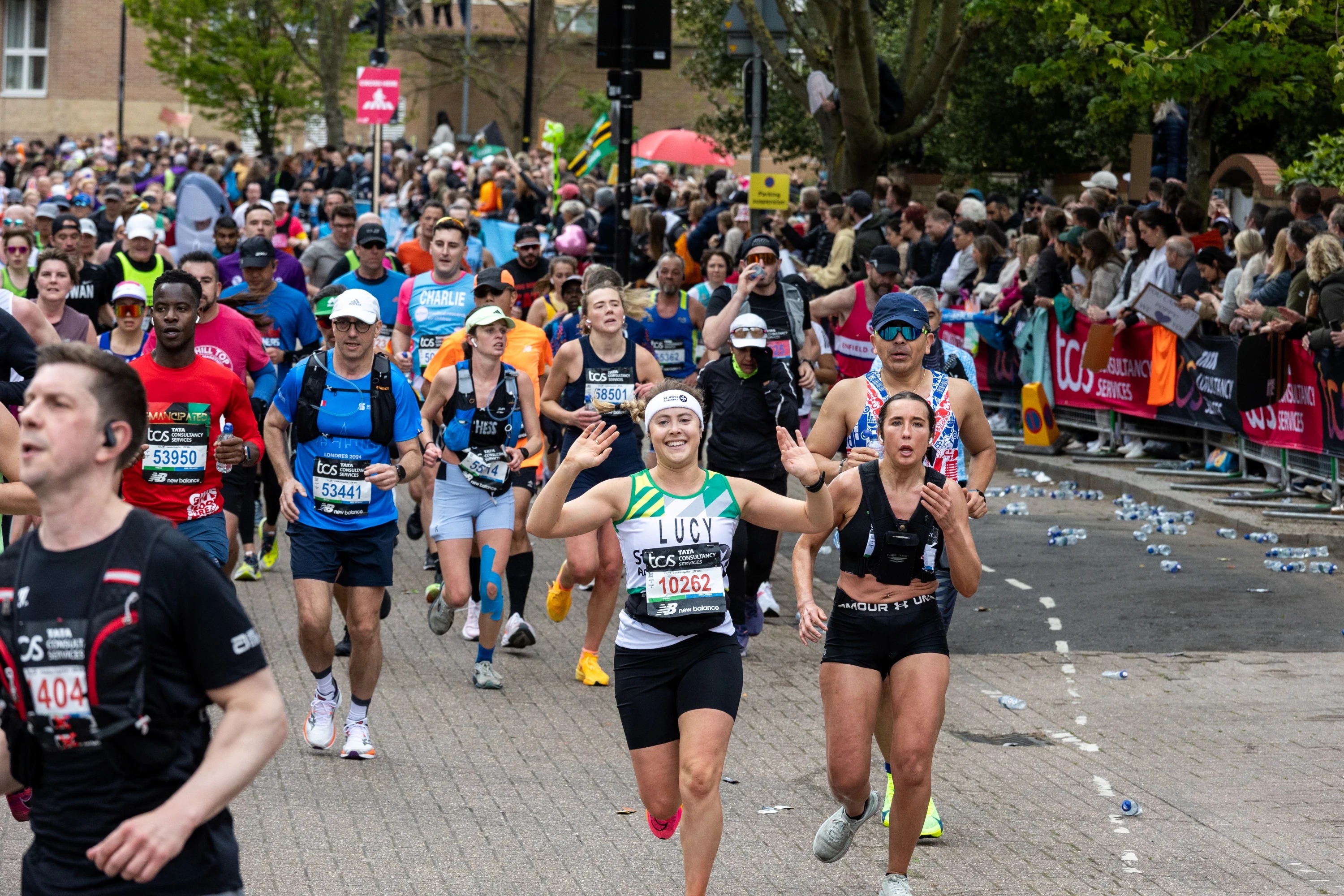 A crowd of marathon runners, with someone running for St John Ambulance at the centre.
