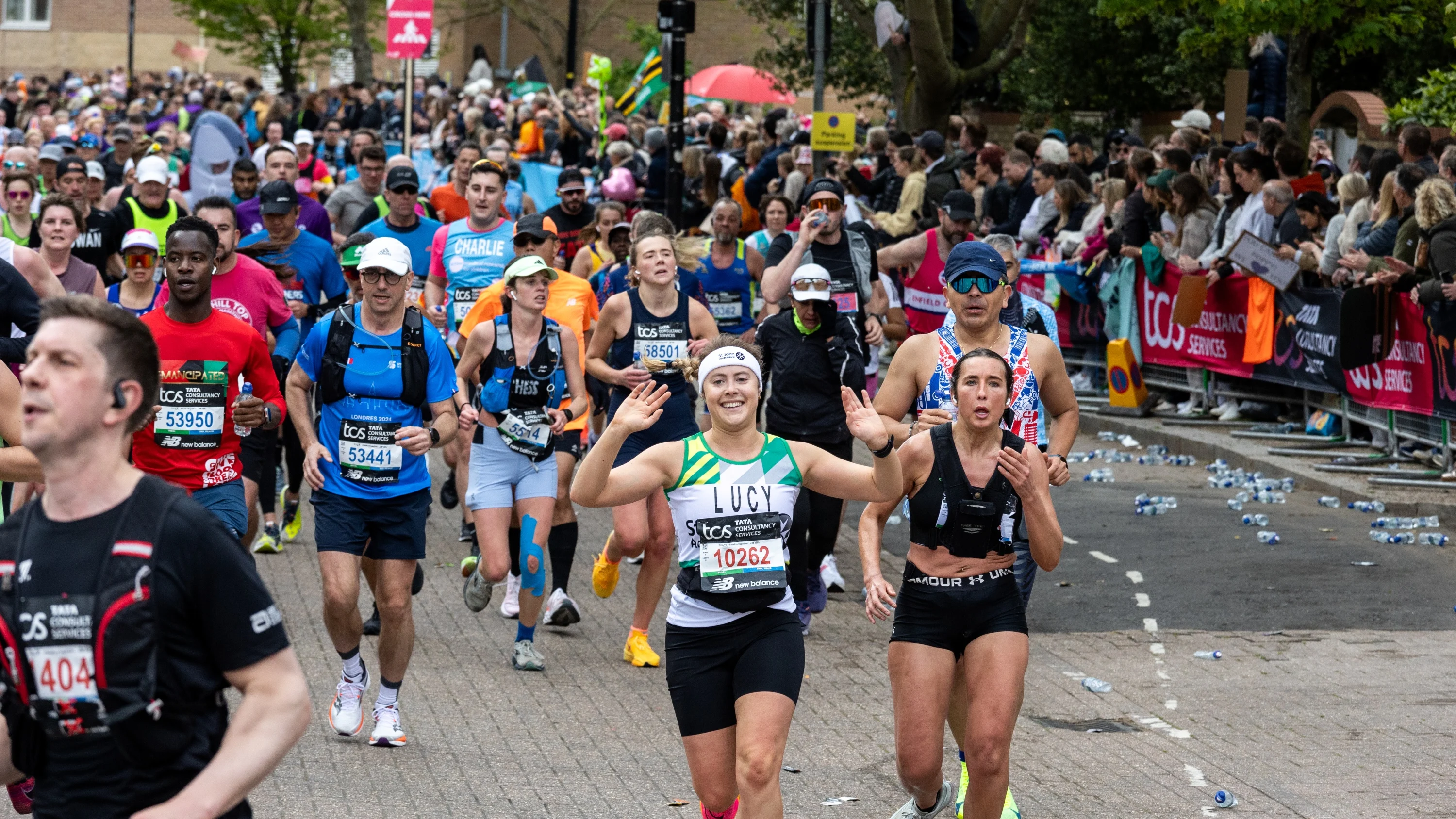 A crowd of marathon runners, with someone running for St John Ambulance at the centre.