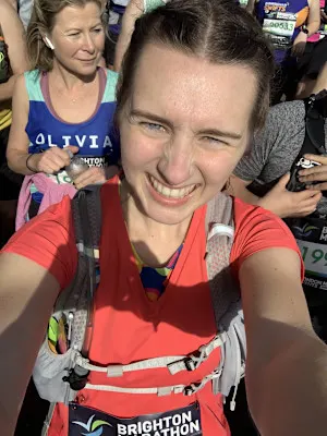 A selfie of Holly during the Brighton Marathon. She is smiling at the camera, surrounded by other runners.