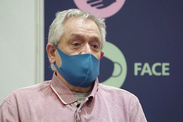 A photograph of Peter wearing a blue, cloth face mask.