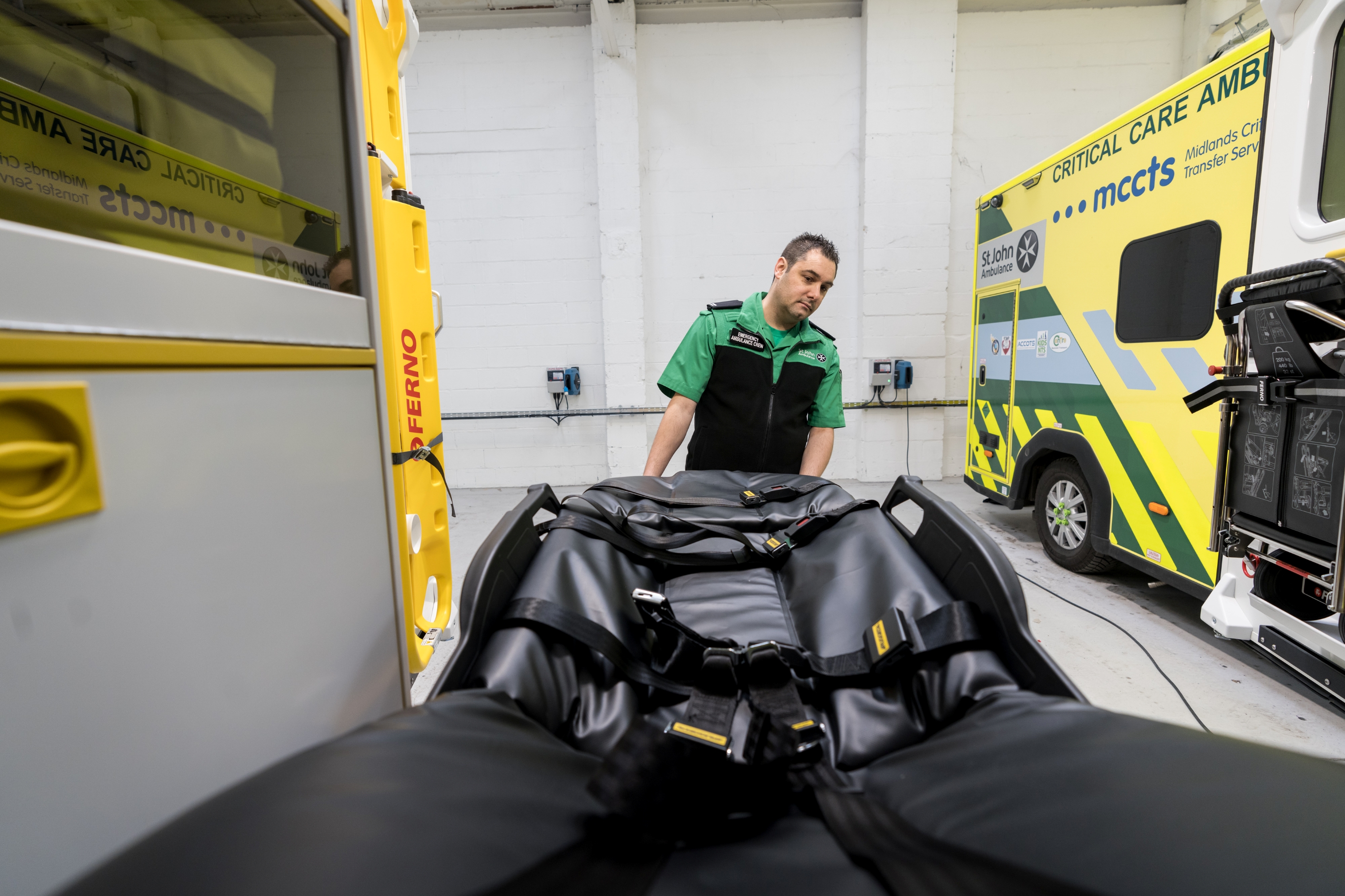 A St John Ambulance worker removing a gurney from the back of one of our emergency ambulances.