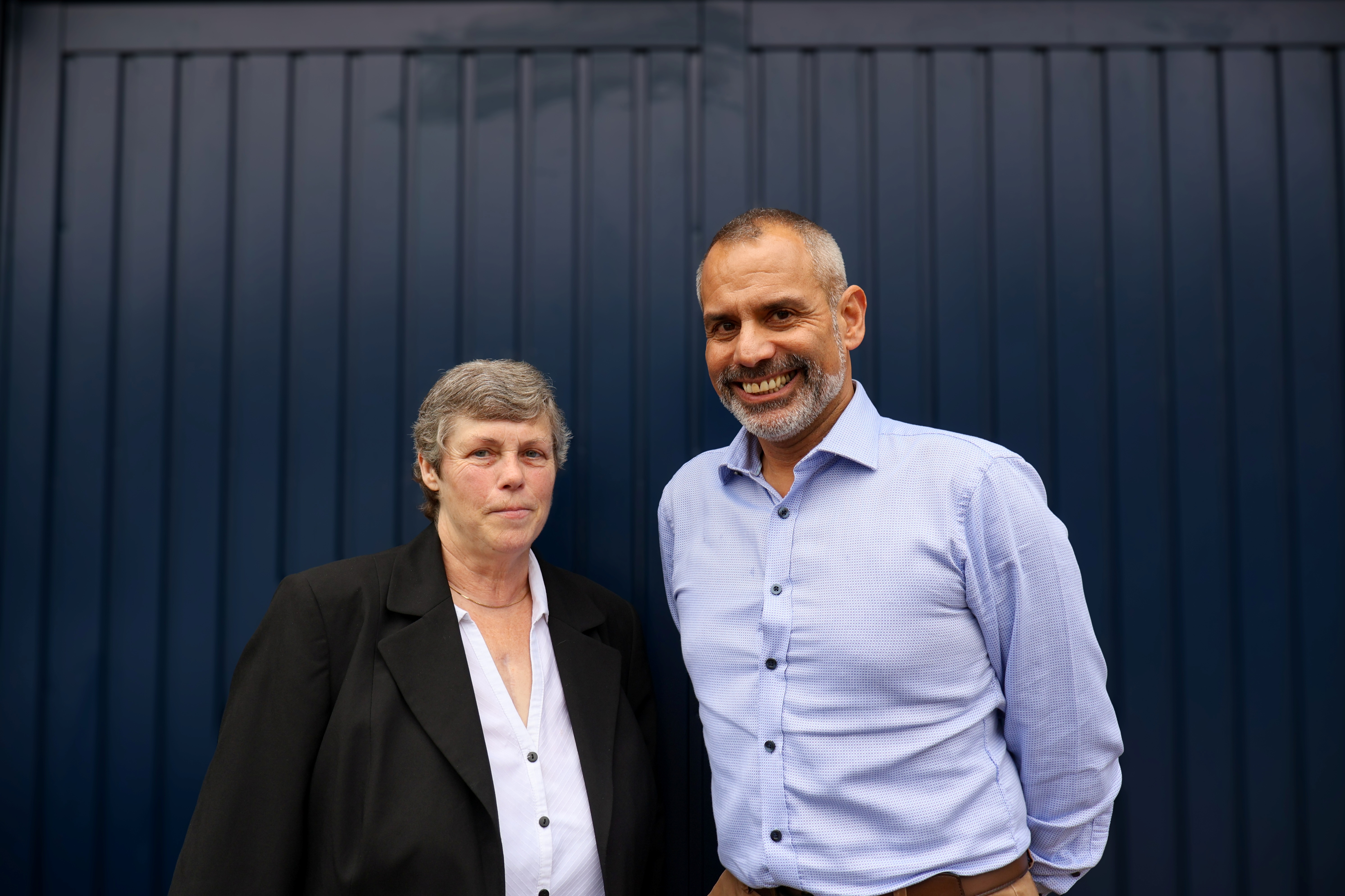 Danny and Suzanne stood next to each other and smiling at the camera.