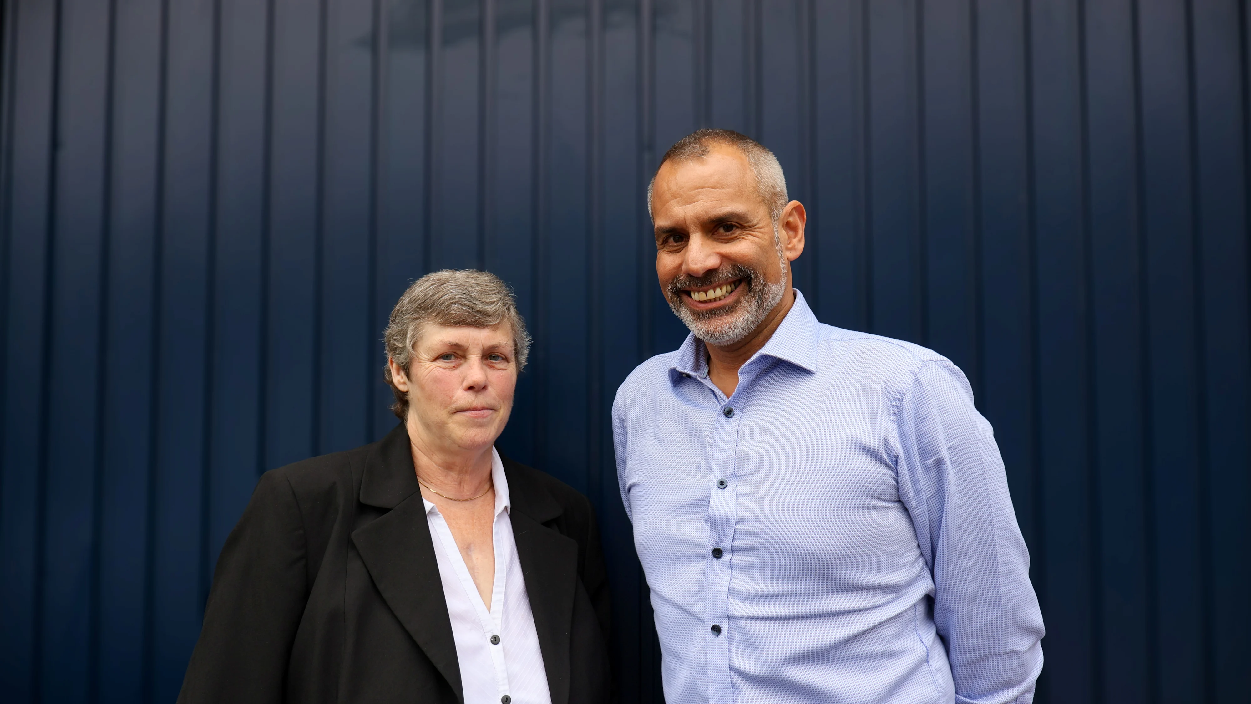 Danny and Suzanne stood next to each other and smiling at the camera.