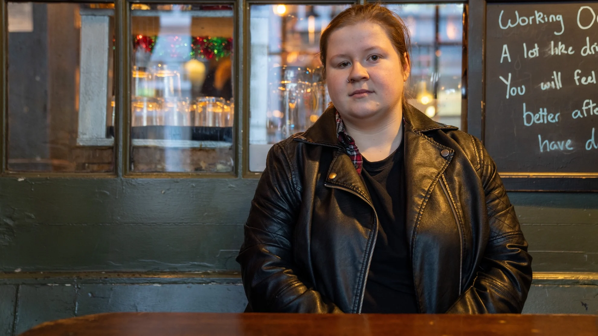 A photograph of Eve sitting at an outdoor table at a pub.