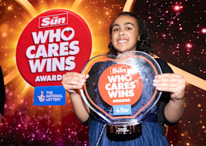 A photograph of Jayden smiling and holding a glass award from 'The Sun: Who Cares Wins Awards'. 
