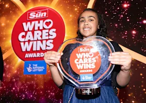 A photograph of Jayden smiling and holding a glass award from 'The Sun: Who Cares Wins Awards'.
