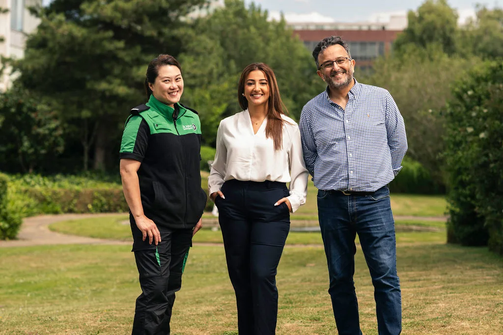 A photograph of Ellna, Douaa and Hussam smiling at the camera.