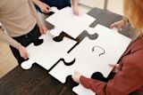Decorative image of group of people putting a puzzle together