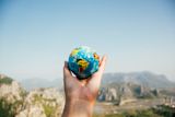 Decorative image of hand holding mini globe for article