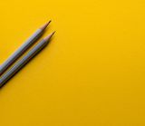 Grey pencils on yellow background