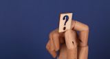 Decorative image of wooden hand holding question mark for article