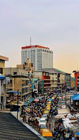 Busy urban street filled with traffic and market stalls