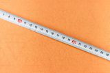 Tape measure on orange background
