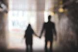 People hold hands out of focus