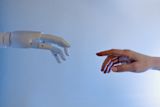 Decorative image of robot hand and human hand reaching out to each other