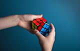 Decorative image of person completing rubiks cube for article
