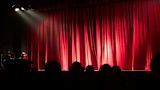 Decorative image of a stage and an audience