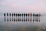 Decorative image of teammates holding hands in a line for article